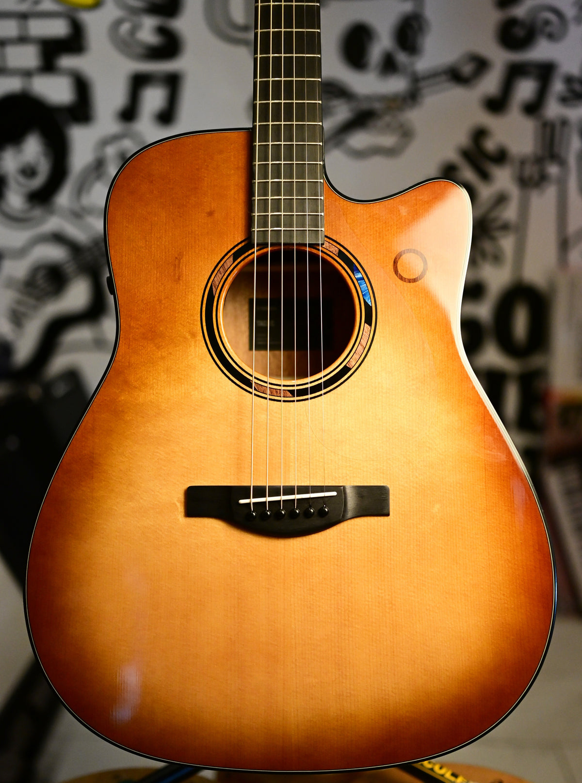 Close-up of the Yamaha TAG3 C Sand Burst solid spruce top, soundhole and ebony bridge