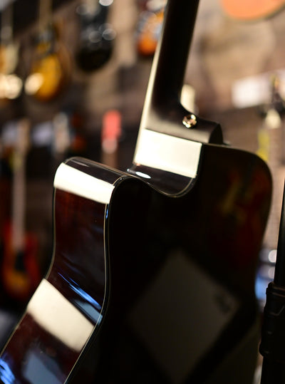Yamaha TAG3 C TransAcoustic cutaway and mahogany back, hanging on display