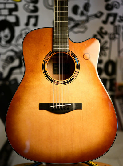 Close-up of the Yamaha TAG3 C Sand Burst solid spruce top, soundhole and ebony bridge